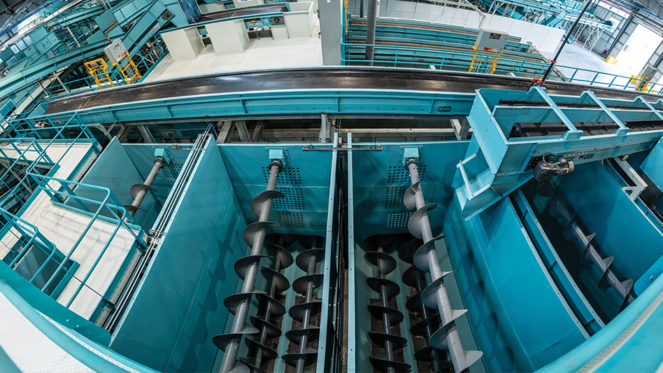 An overhead shot looking down into auger silos in a recycling facility.