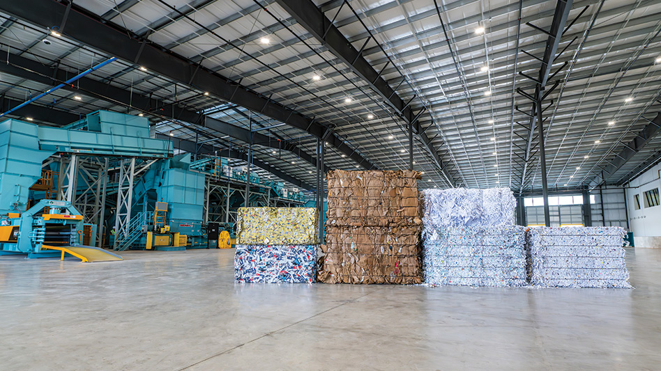 A view of different material grade bales of mixed paper, plastic and cardboard in front of the recycling equipment.