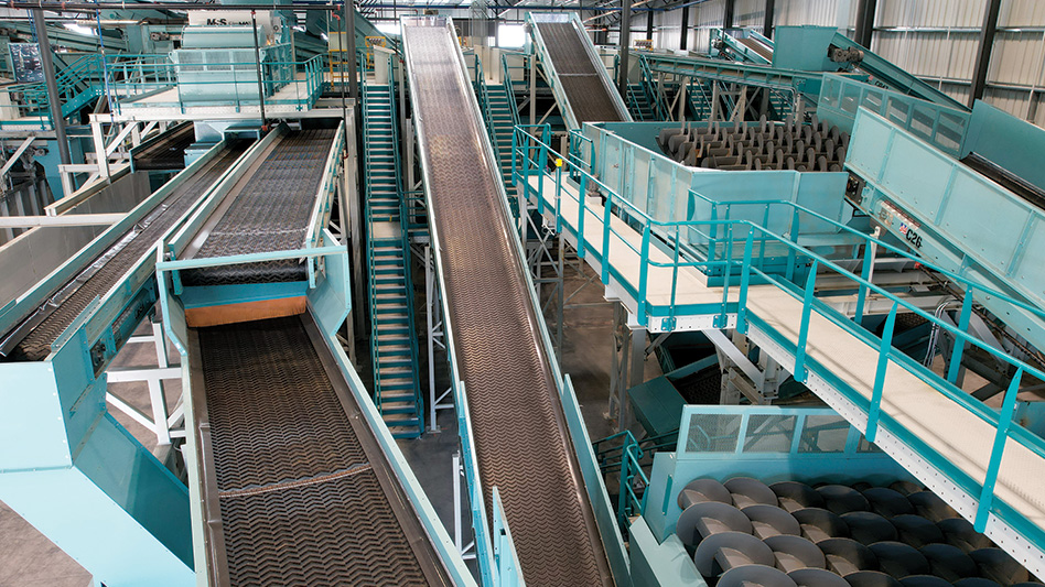 A view of the inside of a recycling facility overlooking conveyor belts, optics, and auger screens.