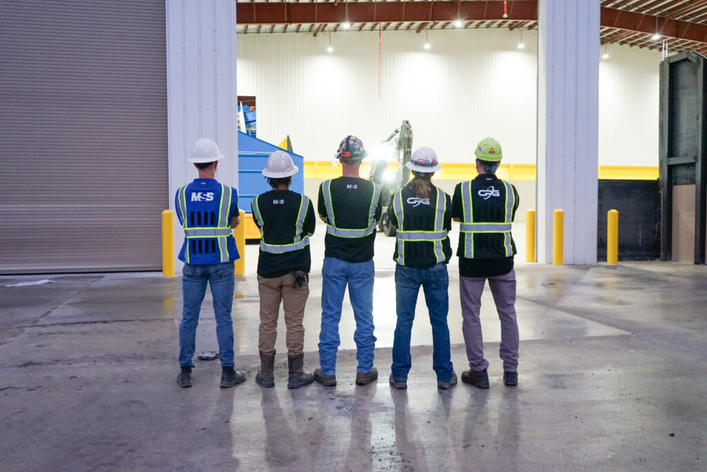 Men standing in front of a MRF with safety gear