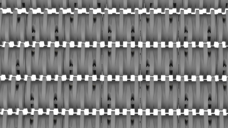 Close-up of a pattern featuring repetitive, interlocking zigzag lines in shades of gray. The zigzag lines are evenly spaced, creating a grid-like appearance that gives the image a textured, woven look.