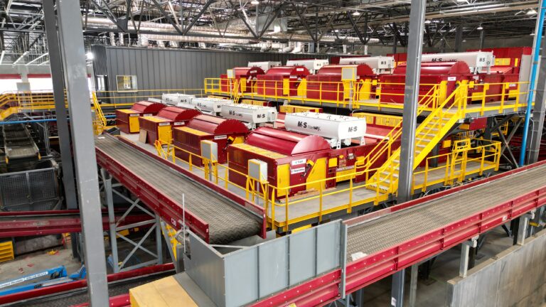 An image overview of red optical sorting equipment in a recycling facility.